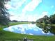 Serene lakefront view with lush landscaping at 29242 Caddyshack Ln, San Antonio, FL 33576