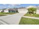 Two-car garage home with a paved driveway and landscaping at 2932 Tanglewylde Dr, Land O Lakes, FL 34638