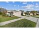 House exterior with a two-car garage and manicured lawn at 2932 Tanglewylde Dr, Land O Lakes, FL 34638