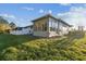 Home exterior showcasing a sunroom addition and well-maintained landscaping at 2932 Tanglewylde Dr, Land O Lakes, FL 34638