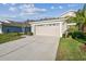 Tan house with a two-car garage and lush landscaping at 2932 Tanglewylde Dr, Land O Lakes, FL 34638