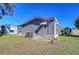 Side yard view of a mobile home with a grassy area and neighboring properties visible at 4853 Blanco Dr, Zephyrhills, FL 33541
