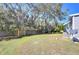 Large backyard with a wooden fence and mature trees at 4853 Blanco Dr, Zephyrhills, FL 33541