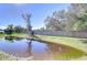 Backyard with a pond reflecting the surrounding trees at 4853 Blanco Dr, Zephyrhills, FL 33541