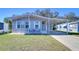 Gray mobile home with carport, landscaped lawn, and seating area at 4853 Blanco Dr, Zephyrhills, FL 33541