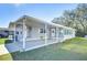 Gray mobile home with carport, landscaped lawn, and seating area at 4853 Blanco Dr, Zephyrhills, FL 33541