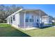 Gray mobile home with carport, landscaped lawn, and seating area at 4853 Blanco Dr, Zephyrhills, FL 33541