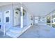 Gray mobile home exterior with covered carport, landscaping, and a fenced backyard at 4853 Blanco Dr, Zephyrhills, FL 33541