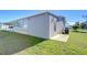 Gray mobile home with a side view showcasing the AC unit and grassy yard at 4853 Blanco Dr, Zephyrhills, FL 33541