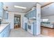 Open kitchen boasts light blue cabinets, white appliances, and view of living room at 4853 Blanco Dr, Zephyrhills, FL 33541