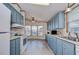 Bright kitchen with light blue cabinets, white appliances, and a large window at 4853 Blanco Dr, Zephyrhills, FL 33541