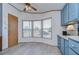 Bright kitchen with light blue cabinets, white appliances, and a large window at 4853 Blanco Dr, Zephyrhills, FL 33541