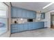 Kitchen features light blue cabinets, white appliances, and ample counter space at 4853 Blanco Dr, Zephyrhills, FL 33541