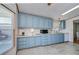 Kitchen features light blue cabinets, white appliances, and ample counter space at 4853 Blanco Dr, Zephyrhills, FL 33541