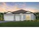 Two-story home with gray exterior, three-car garage, and landscaped lawn at 6136 Jensen View Ave, Apollo Beach, FL 33572