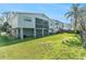 House backyard with a green lawn, wooden fence, and palm trees at 7029 Oakwood Dr, New Port Richey, FL 34652