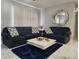 Living room with navy blue sofas and a large circular mirror at 8106 N Rome Ave, Tampa, FL 33604