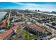 Aerial view of the condo complex, mature landscaping, pond, and surrounding neighborhood at 8711 Blind Pass Rd # 307A, St Pete Beach, FL 33706
