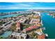 Aerial view showcasing coastal community, boat docks, tennis courts, and waterfront access at 8711 Blind Pass Rd # 307A, St Pete Beach, FL 33706