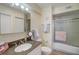 Well-lit bathroom features a granite countertop, framed mirror, and a combined shower and tub with sliding glass doors at 8711 Blind Pass Rd # 307A, St Pete Beach, FL 33706