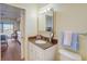 Bright bathroom featuring granite countertop, white cabinets, medicine cabinet, and a view into the bedroom at 8711 Blind Pass Rd # 307A, St Pete Beach, FL 33706