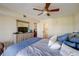 A well lit bedroom with an en suite bathroom, ceiling fan, and dresser with a television at 8711 Blind Pass Rd # 307A, St Pete Beach, FL 33706