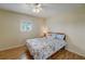 Cozy bedroom with wood floor, ceiling fan, shuttered window, and seashell-themed comforter at 8711 Blind Pass Rd # 307A, St Pete Beach, FL 33706