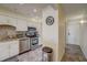 Functional kitchen with stainless steel appliances, white cabinets, and easy access to the entrance hall at 8711 Blind Pass Rd # 307A, St Pete Beach, FL 33706
