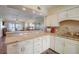 Open kitchen with granite countertops, white cabinets, and a pass-through to the living room at 8711 Blind Pass Rd # 307A, St Pete Beach, FL 33706