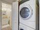 Convenient laundry area featuring stacked washer and dryer, plus a view into the bathroom at 8711 Blind Pass Rd # 307A, St Pete Beach, FL 33706