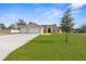House exterior showcasing a two-car garage and lush lawn at 13254 Kitty Rd, Weeki Wachee, FL 34614