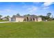 House exterior with a two-car garage and manicured lawn at 13254 Kitty Rd, Weeki Wachee, FL 34614