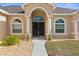 Arched entryway with double doors and landscaping at 13254 Kitty Rd, Weeki Wachee, FL 34614