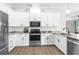 Modern kitchen with white cabinets, granite countertops, and stainless steel appliances at 13254 Kitty Rd, Weeki Wachee, FL 34614