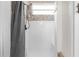 Clean and bright shower with white tile and a gray shower curtain at 13254 Kitty Rd, Weeki Wachee, FL 34614