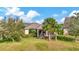 Home with screened patio, lush landscaping, and expansive lawn at 16340 Treasure Point Dr, Wimauma, FL 33598