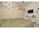 Bedroom with floral wall mural, dresser, and TV at 16340 Treasure Point Dr, Wimauma, FL 33598