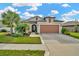 Single-Gathering house with a two-car garage and a well-manicured lawn at 16340 Treasure Point Dr, Wimauma, FL 33598