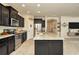 Modern kitchen with dark cabinets, granite counters, and stainless steel appliances at 16340 Treasure Point Dr, Wimauma, FL 33598