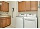 Laundry room with washer, dryer, and wood cabinets at 16340 Treasure Point Dr, Wimauma, FL 33598