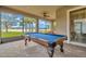 Screened lanai with a pool table overlooking a lake at 16340 Treasure Point Dr, Wimauma, FL 33598