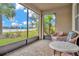 Relaxing screened lanai with lake view and wicker furniture at 16340 Treasure Point Dr, Wimauma, FL 33598