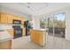 Kitchen with light wood cabinets, black appliances, and an island at 3117 Bayshore Oaks Dr, Tampa, FL 33611