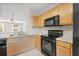 Functional kitchen with wood cabinets and black appliances at 3117 Bayshore Oaks Dr, Tampa, FL 33611