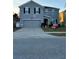 Two-story house with gray siding, two-car garage, and landscaped lawn at 451 Hartford Heights St, Spring Hill, FL 34609