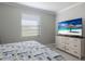 Bedroom with a queen bed, dresser, and large TV at 5211 Marina Basin Ct, Bradenton, FL 34211