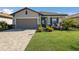 Front view of a single-story house with a paved driveway and palm trees at 5211 Marina Basin Ct, Bradenton, FL 34211