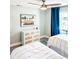 Bright bedroom with twin beds, dresser, and beach-themed art at 690 Fox St, Longboat Key, FL 34228