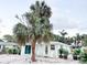 Charming light teal home with a spacious front yard and lush landscaping at 690 Fox St, Longboat Key, FL 34228