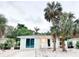 Cute bungalow with a light teal exterior, palm trees, and a white-washed front porch at 690 Fox St, Longboat Key, FL 34228